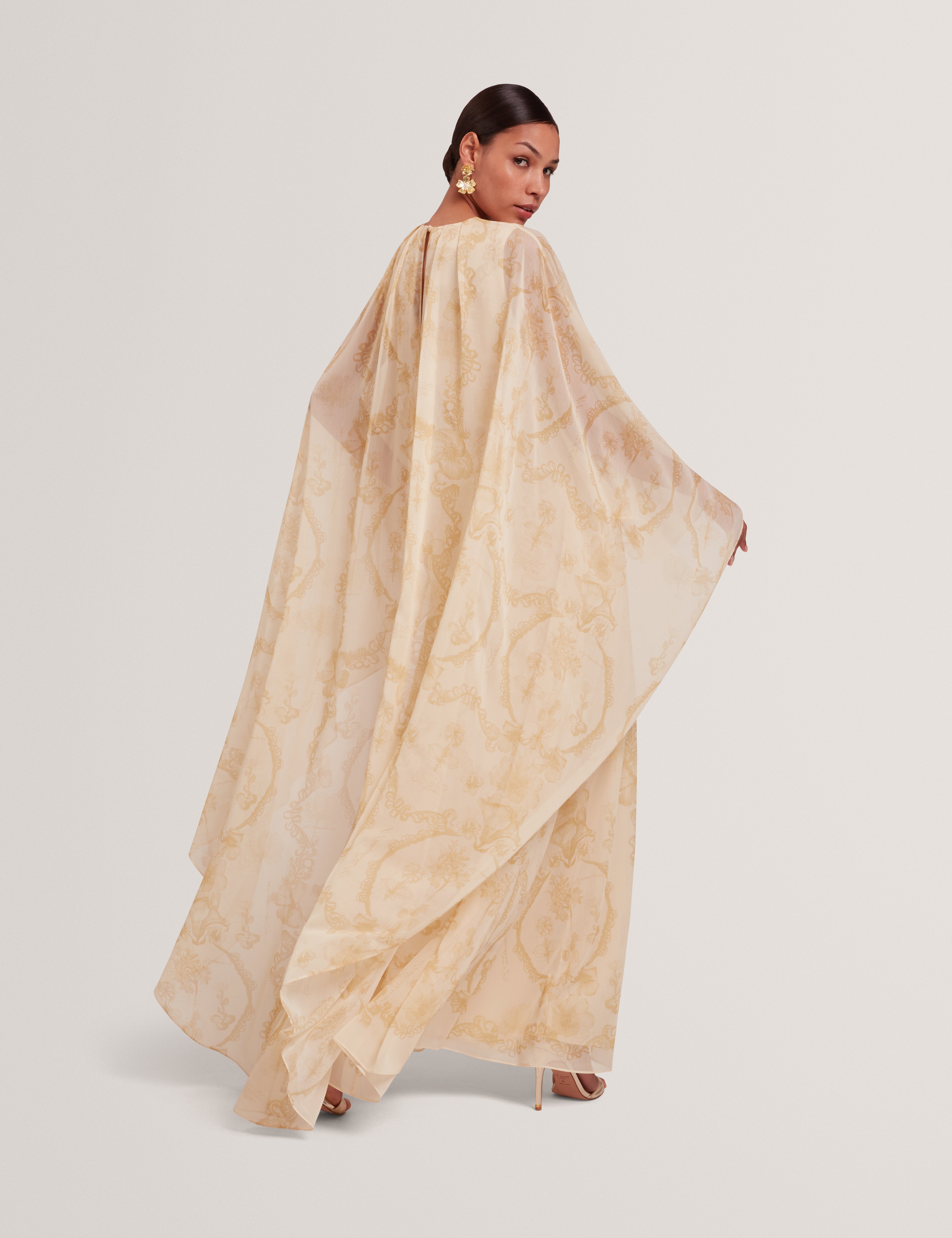 فستان ماكسي نييفا بتفاصيل كيب وشلال، لون أصفر فاتح